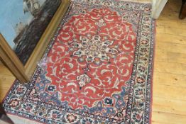 A Tabriz rug, with trailing foliate design on a red field. 144cm by 105cm