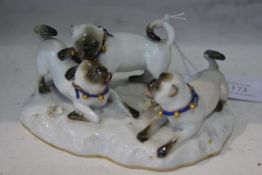 A Meissen porcelain pug group, the three puppies each modelling wearing a collar with bells on a