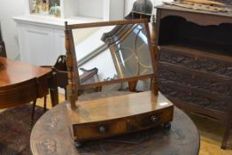 An early Victorian mahogany toilet mirror, the rectangular plate swivelling between baluster