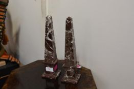 A pair of marble obelisks, of characteristic form, with deep maroon and white striations, 20th