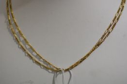 A late 19th/early 20th century yellow metal guard chain, of fancy links, with lobster clasp,