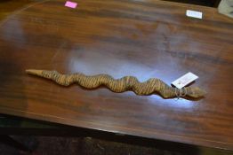 An Aborigine carved wooden snake totem, with burnt incised linear decoration. Length 52cm Note: