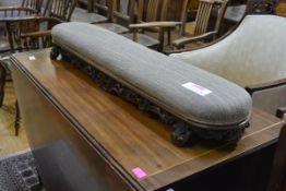 A 19th century rosewood framed fireside stool, the seat with bowed ends raised on an elaborately