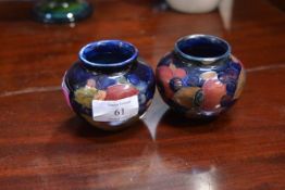 A pair of Moorcroft small squat baluster vases, in the Pomegranate pattern against a blue ground,