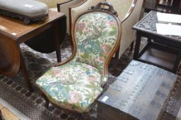 A Victorian walnut-framed spoon back nursing chair, with scroll carved crest, bowed seat and