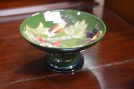 A Moorcroft pedestal bowl in the Honeysuckle pattern, on a green ground, Walter Moorcroft monogram