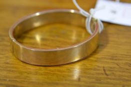 A late 19th/early 20th century 9ct gold bangle, with safety chain. 15 grams