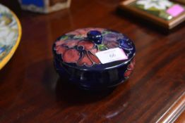 A Moorcroft powder jar and cover, circular, in the Anemone pattern against a blue ground,