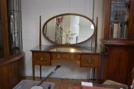 An Edwardian marquetry inlaid mahogany dressing table, the breakfront rectangular top above an