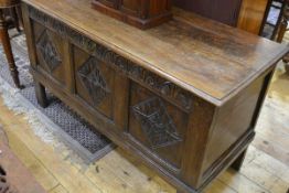 A carved oak coffer, c. 1700, the rectangular moulded top above a three panel front, each panel