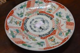 A Japanese porcelain charger, in the Chinese taste, c. 1900, polychrome painted with panels of birds