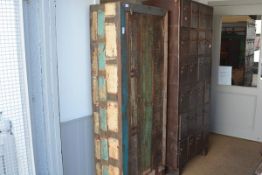 A distressed painted rustic cupboard, with plain rectangular frame enclosing a planked door with