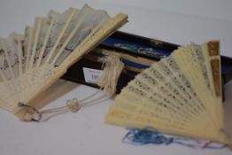 An early 20th century Chinese ivory and embroidered silk fan, the terminals worked with flowers