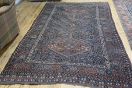 A Caucasian rug with triple diamond shaped medallions enclosed within a rectangular border with