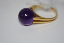 A contemporary dress ring, set with an amethyst sphere, mounted on split shoulders in (unmarked)