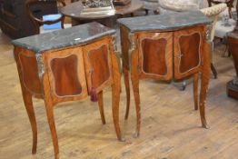 A pair of Louis XV style bombe, marble topped, gilt metal mounted kingwood bedside cabinets, each