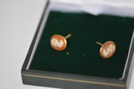 A pair of 9ct gold shell cameo earrings, each oval plaque within a gold frame, on post and butterfly