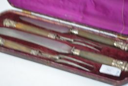 A mid-Victorian cased four piece carving set, each piece with wooden handles mounted in white