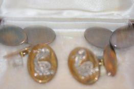 A pair of silver and silver-gilt chainlink cufflinks, each oval plaque mounted with a rearing cobra,