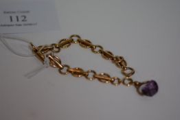 A 9ct yellow gold fancy link bracelet, with swivelling amethyst glass fob. Gross 14.1 grams