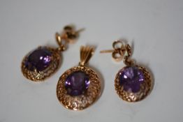 A gold filigree pendant set with an oval cut synthetic corundum, the bale indistinctly stamped but