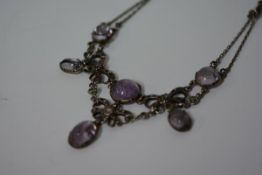 An amethyst and white metal necklace in the Edwardian taste, set with amethyst cabochons of