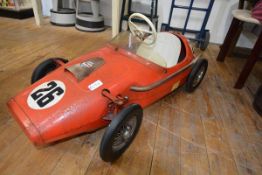 A 1960's Tri-ang pedal toy racing car, in red, with decals