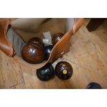 A set of four lignum vitae lawn bowls; together with two Thomas Taylor bowls, in a carrying case (