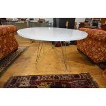 A modernist white polymer circular dining table with chrome base