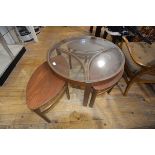 A Nathan vintage glass topped teak coffee table, of circular form, the shaped stretchers enclosing