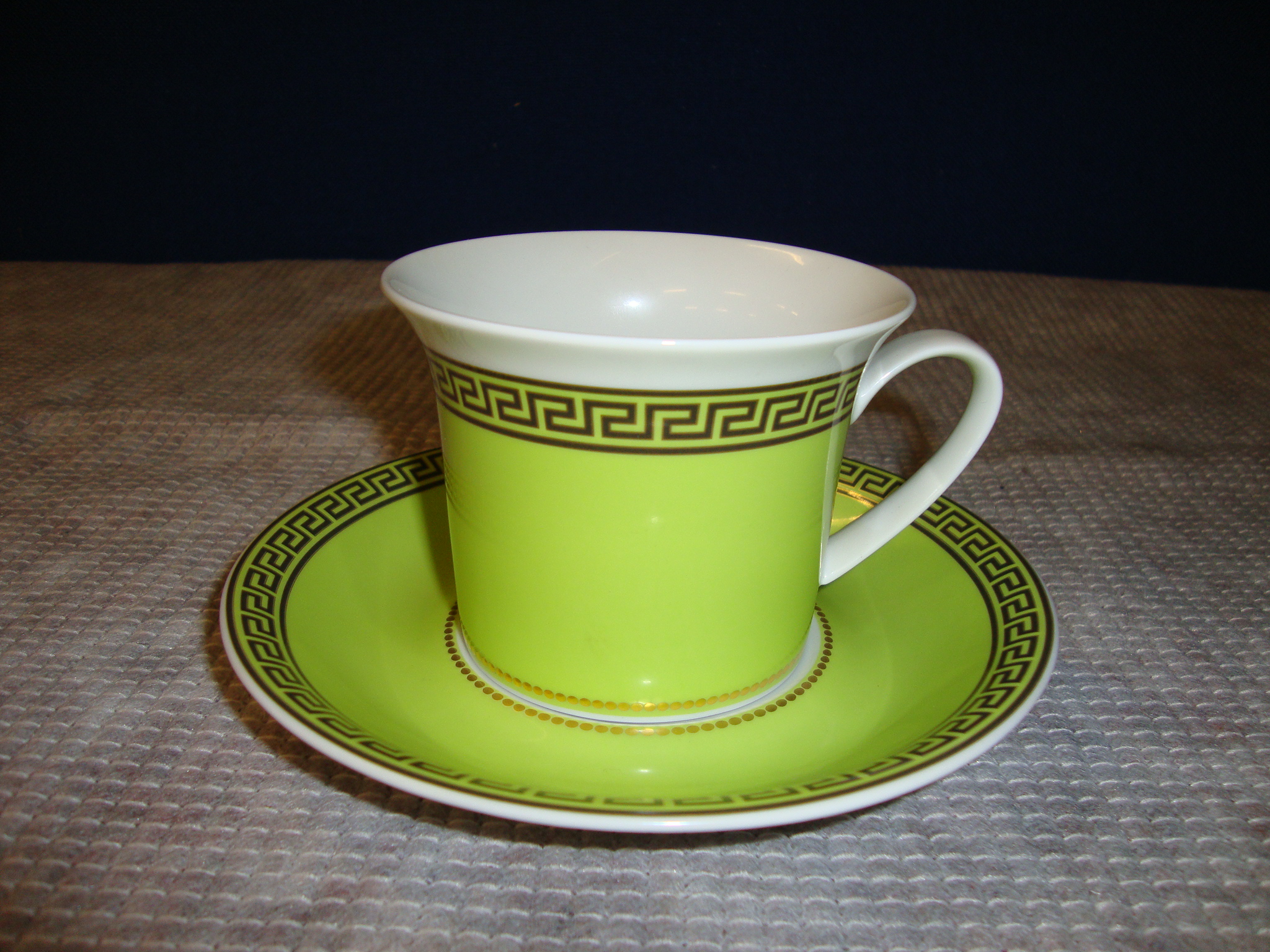 Versace by Rosenthal green and gold teacup and saucer, with primarily gold design Medusa head in the