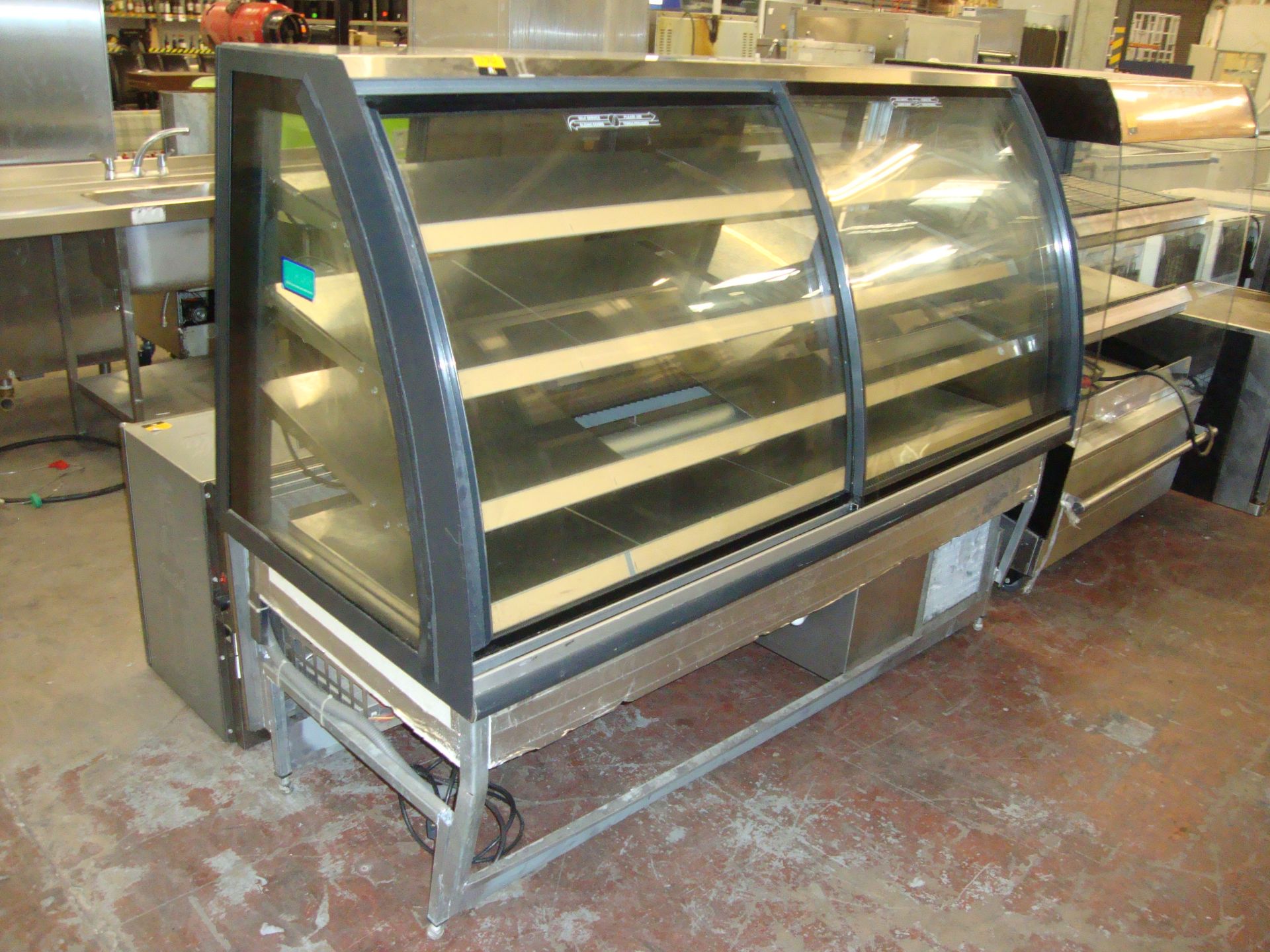 Large refrigerated serving counter with twin clear curved sliding doors on the customer side &