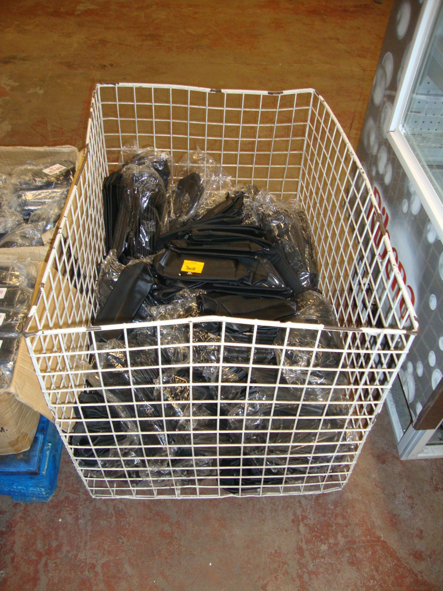 The contents of a cage containing a very large quantity of black zip up cosmetic pouches/toiletry