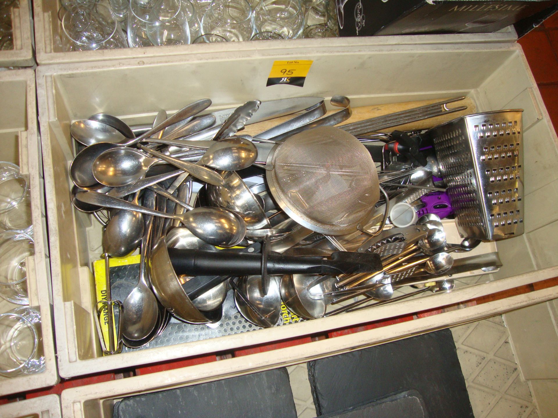 The contents of a crate of assorted cutlery & utensils
