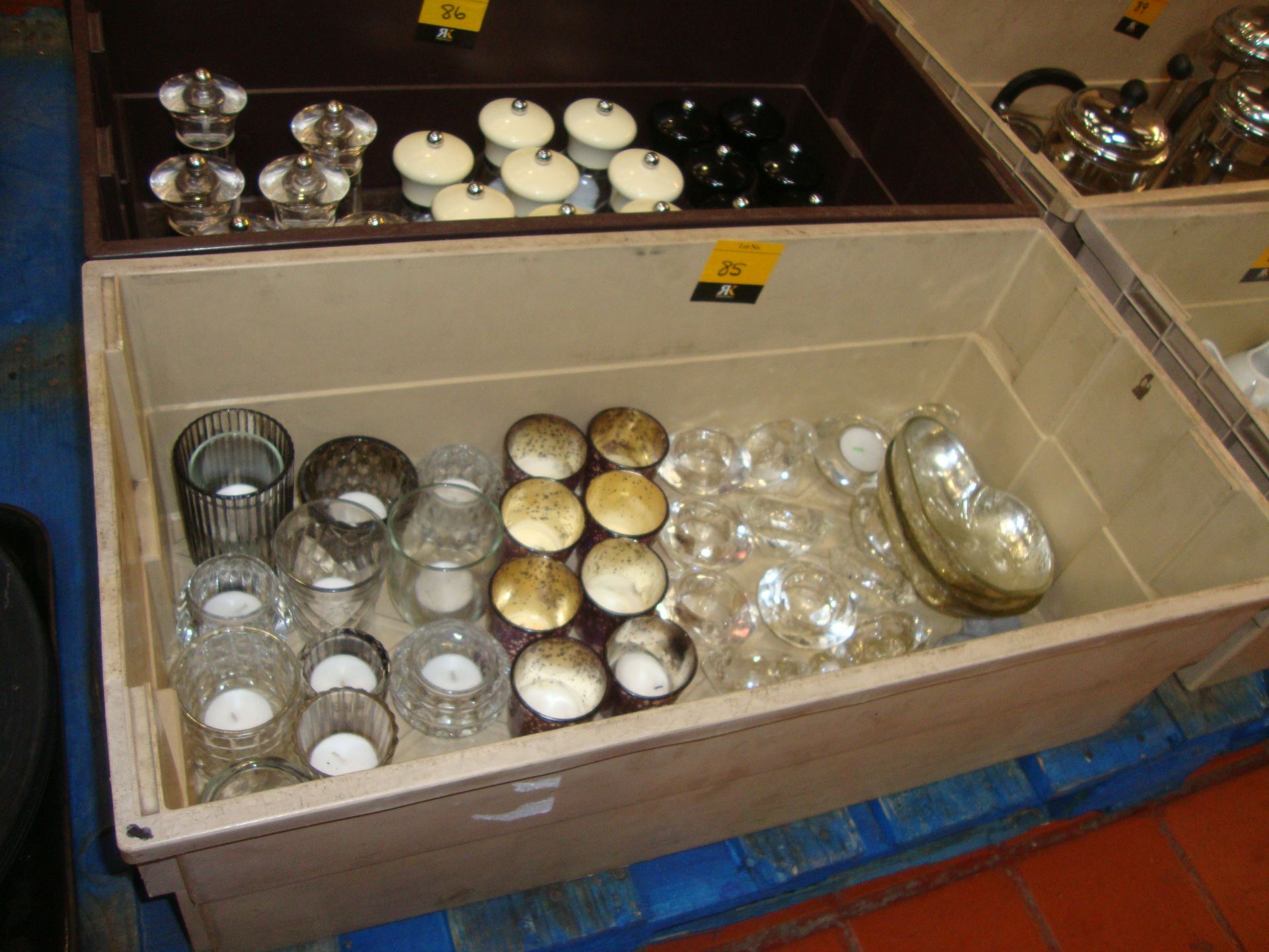 The contents of a crate of tea light holders & similar