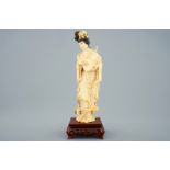 A Chinese carved ivory figure of a lady with hand drum on wooden base, early 20th C. [...]