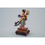 A Chinese polychrome carved ivory figure of a lady with flowers on wooden base, early [...]