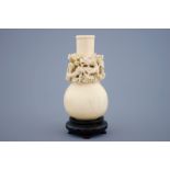 A Chinese carved ivory dragon vase on a wooden base, early 20th C. - Dim.: 18,5 x 8,5 [...]