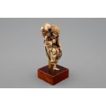 A Japanese ivory okimono of a lady with dogs, Meiji, 19th C. - H.: 12 cm Signed on [...]