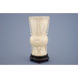 A Chinese carved ivory vase of archaic form on a wooden base, 19th C. - Dim.: 25,5 x [...]