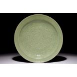 A Chinese celadon dish with incised lotus design, 19th C. Dia.: 27,5 cm Condition reports and high