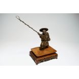 A Japanese bronze model of a fisherman on wooden base, Meiji, signed Dim.: 44 x 42 x 24,5 cm