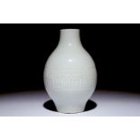 A Chinese monochrome white-glazed olive-shaped vase with underglaze design, Qianlong mark, 19th C.