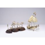 A Chinese silver model of a junk and one of a dragon parade, 19/20th C. L.: 22,5 cm - W.: 9,5 cm -