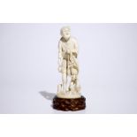 A Japanese ivory okimono of a fisherman on wooden base, Meiji, 19th C., signed H.: 22,5cm (incl.