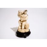 A Chinese carved ivory figure of a girl with grapes, 2nd quarter 20th C. H.: 18,5 cm (incl. base)