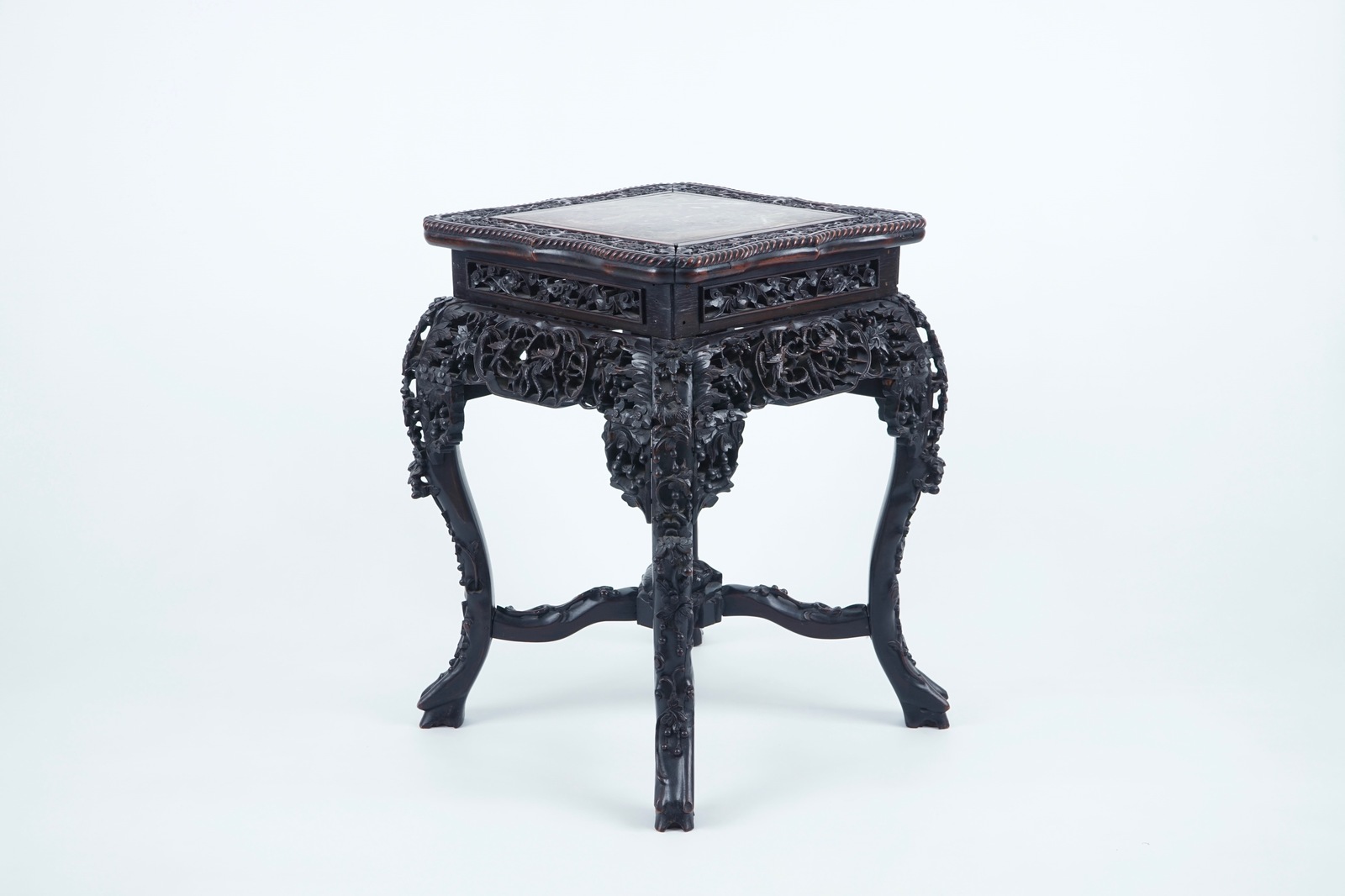 An intricately carved square Chinese wood stand with marble top, 19th C. H.: 63,5 cm - Dim.: 44 x 44