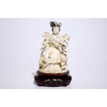 A Chinese ivory figure of a lady playing a flute on wooden base, early 20th C. H.: 24,5 cm Condition