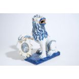 A large Dutch Delft figure of a lion with a coat of arms, 19th C. H.: 24 cm Condition reports and