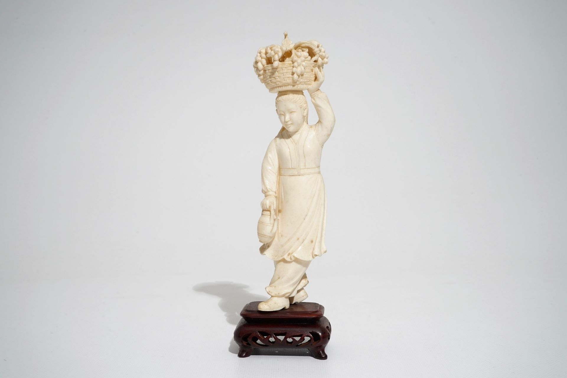 A Chinese carved ivory figure of a lady with a fruit basket, 2nd quarter 20th C. - Image 2 of 7